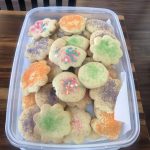 A container of Easter cookies topped with sanding sugar.